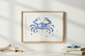 Framed artwork of a blue crab with gold accents on a white background
