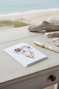 Floral heart-shaped card with a white envelope on a light gray background