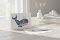 Greeting card with a whale design on a white background