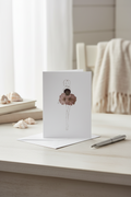 Greeting card with a stylized pressed flower ballerina in a tutu on a white background
