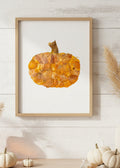 An autumn-themed decorative pumpkin crafted from layered dried orange and yellow leaves, featuring a textured stem at the top, isolated on a white background.