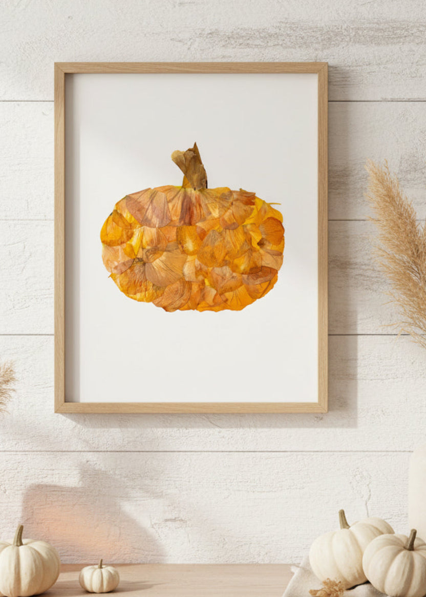 An autumn-themed decorative pumpkin crafted from layered dried orange and yellow leaves, featuring a textured stem at the top, isolated on a white background.